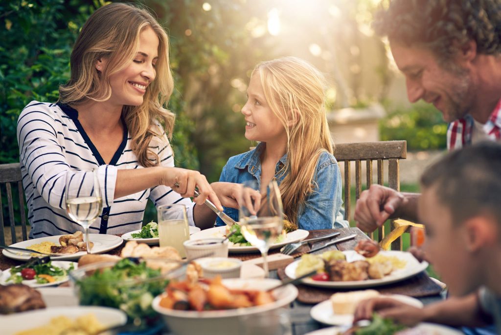 Famille dégustant un repas ensemble dans un environnement convivial | Le Petit Décante